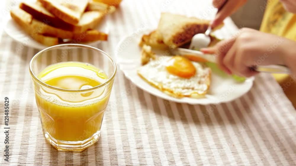 Boy eats his breakfast consisting of a fried egg, some toast and orange juice Boy eats his breakfast consisting of a fried egg, some toast and orange juice