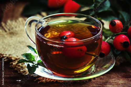 Curative tea with rosehip, folk medicine, Vintage wood backgroun