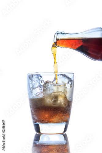 Cola pouring in a glass on white background