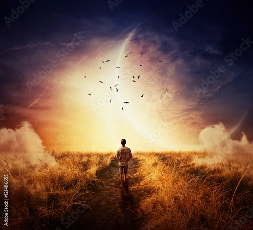 Boy walking on a pathway with a relax mood, following a group of birds on the space horizon. Way of life concept photo