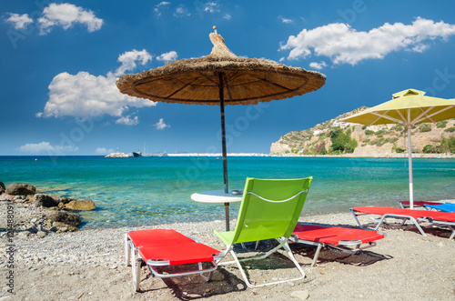Straw umbrella on a sandy beach in Greece. 