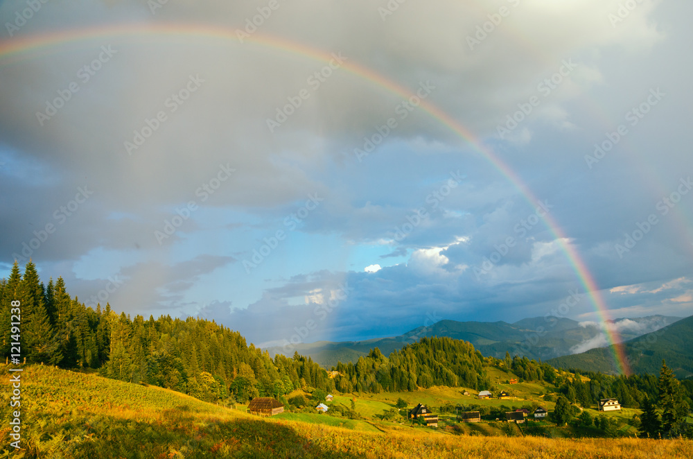 Naklejka premium Rainbow in the mountain valley after rain. Beautiful landscape in Carpathians. Ukraine