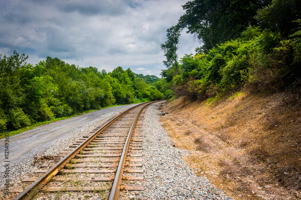 Fototapeta premium Dirt road and railroad track in rural Carroll County, Maryland.
