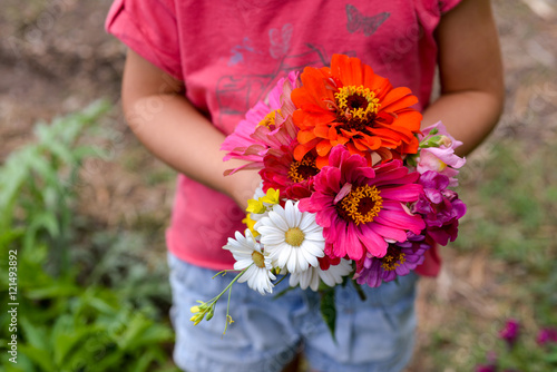 petite fille tenant un bouquet de fleurs