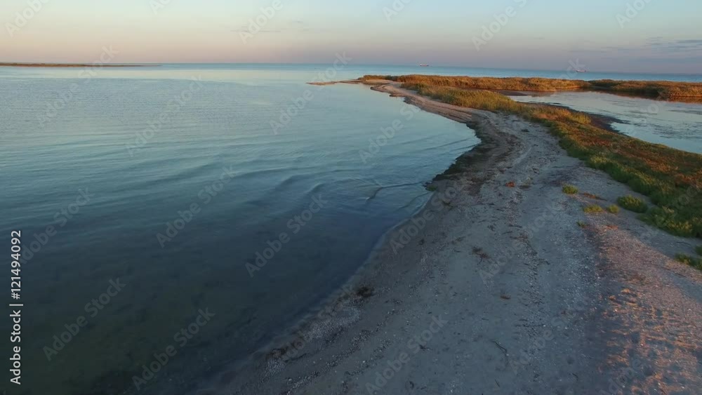Flying over sea coast during sunrise. Sandy beaches, bays, a fishing village - aerial view. Flying over sea coast during sunrise. Sandy beaches, bays, a fishing village - aerial view.