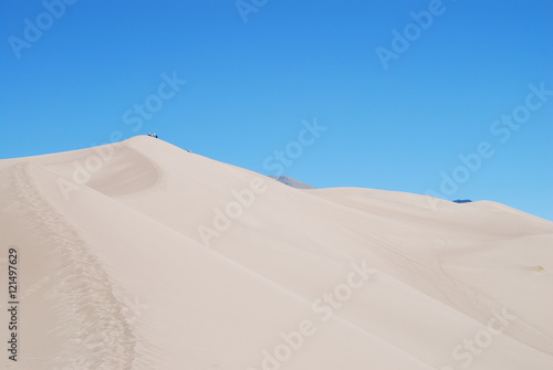 Footprints and hikers walking on the crest of High dune in Great Sand Dunes National Park  CO  USA