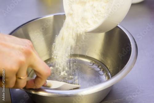 Preparation of the dough. The cook pours the flour into the bowl