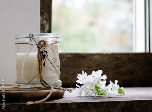 rustic still life. milk in a glass jar  flowers. vintage  wooden background  window and fresh produce