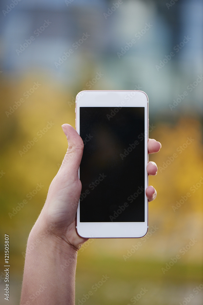 Hand holding white mobile phone