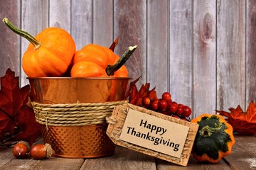 Happy Thanksgiving tag, pumpkins, leaves and autumn home decor with rustic wood background