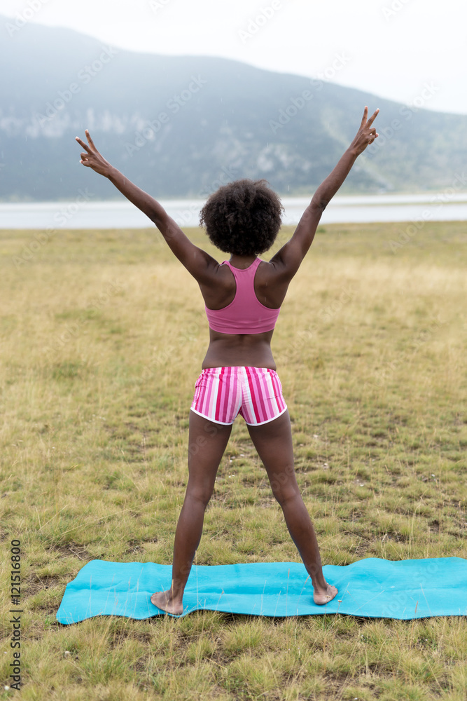 Woman practicing yoga positions on grass in mountains Woman practicing yoga positions on grass in mountains