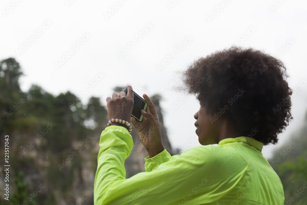 Fototapeta premium Beautiful afro american woman taking photos outdoors in a forest