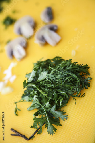 fresh parsley lying as bundle on yellow surface, some blurry vegetables in background, preparing fanesca concept © Fotos 593