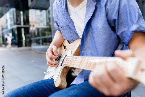 Young musician with guitar in city