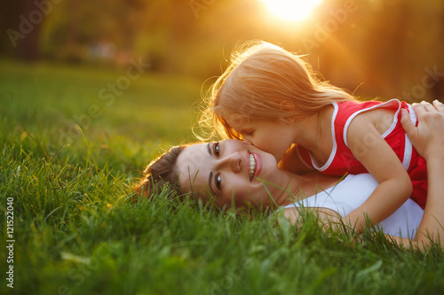 Fotografi Mother and daughter lying on grass