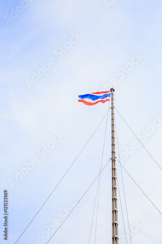 Waving Thai national flag with background blue sky.