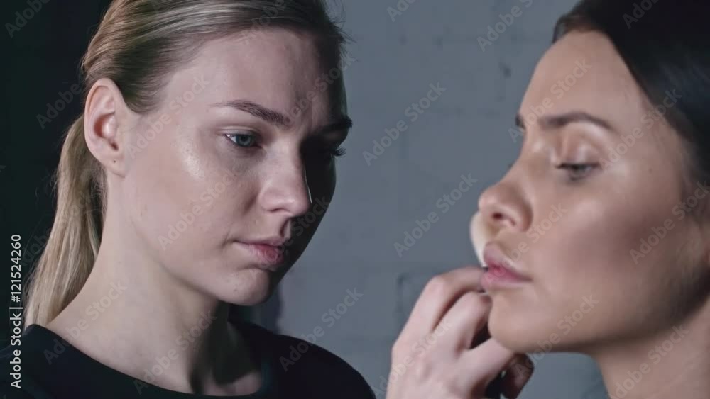 Female makeup artist working on beauty look of young model Female makeup artist working on beauty look of young model