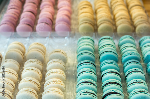 Set of different french colorful cookies macaroons in plastic box on candy bar at the fair. Sweet dessert, hipster love this macaroon-cakes. Cookies on the street food festival. blurred background