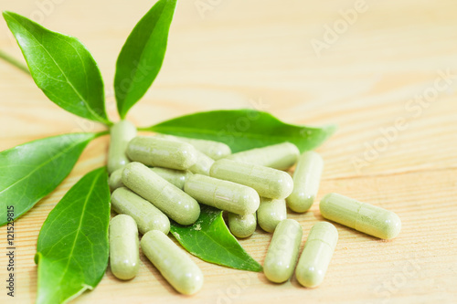 Schefflera leucantha green herbal powder in the capsule, safe medicine concept. photo