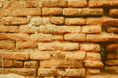 old brick wall, vintage eroded orange brick wall of temple in Thailand.