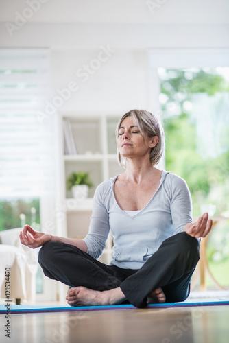 Free Download a pretty woman senior who does yoga at home, she meditates - GFXLoad