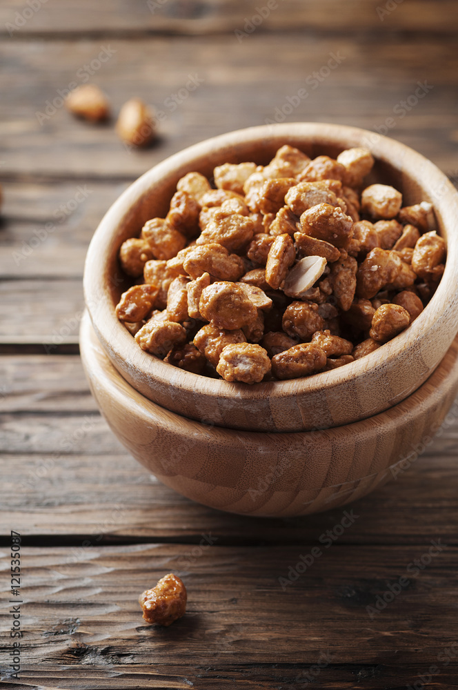 Sugared peanuts on the wooden background