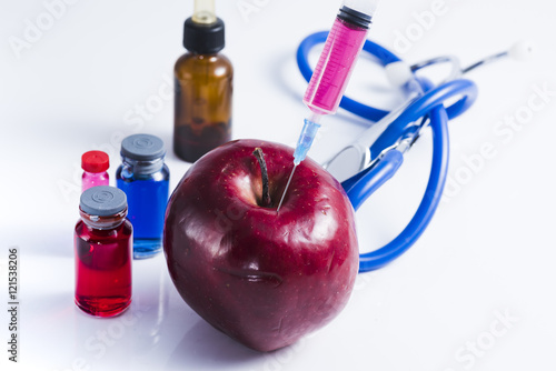injecting dangerous substances on food. Concept for genetically modified foods.