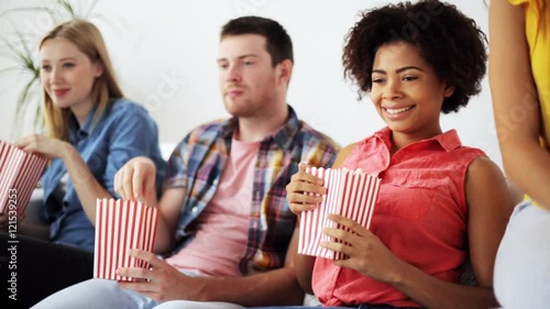 happy friends with popcorn watching tv at home photo