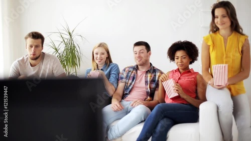 happy friends with popcorn watching tv at home photo