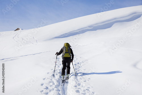 personne qui marche dans la neige au sommet des montagnes