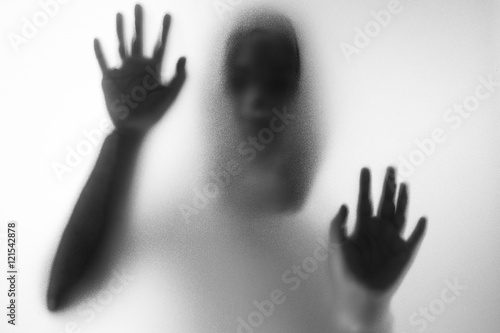 Quadro su tela Horror woman behind the matte glass in black and white. Blurry h