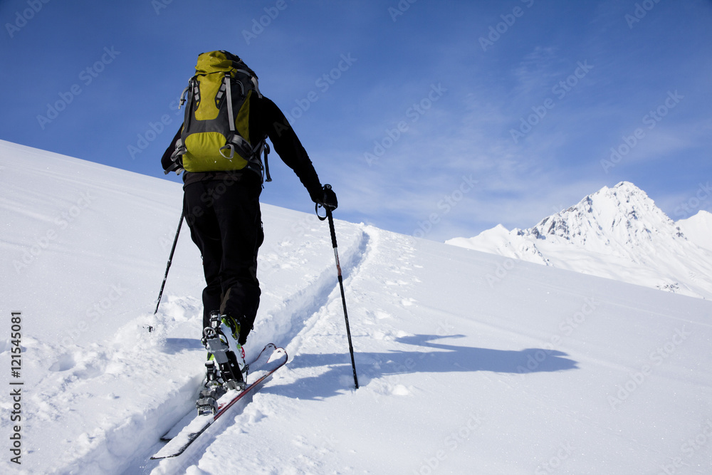 personne qui marche dans la neige au sommet des montagnes avec des peaux de phoque