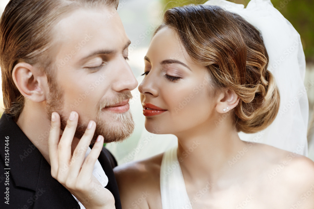 Young beautiful newlyweds smiling with closed eyes, enjoying. Young beautiful newlyweds smiling with closed eyes, enjoying.