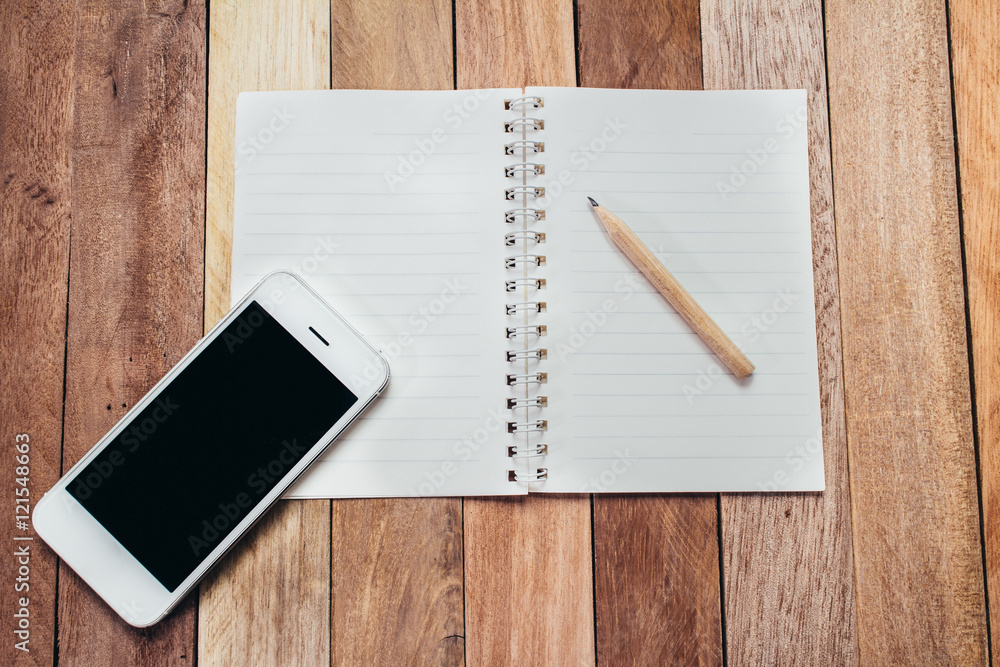 Top view of office business working notebook pencil pen smartphone on wooden background