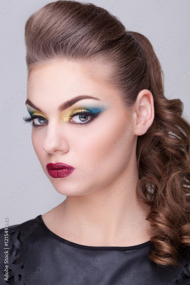 Girl with green and yellow make up on gray background Girl with green and yellow make up on gray background