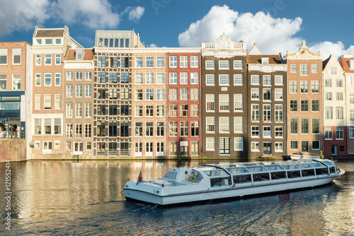 Amsterdam canal cruise ship with Netherlands traditional house 