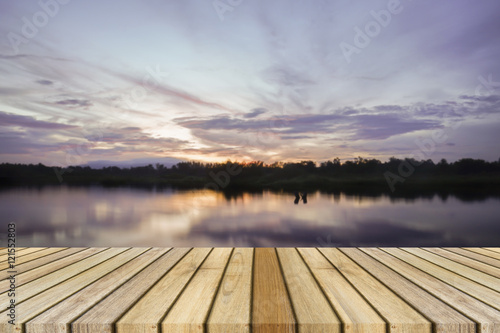 Fototapeta Naklejka Na Ścianę i Meble -  Empty top wooden decking and sunset moment at little lake background. Can use for product display