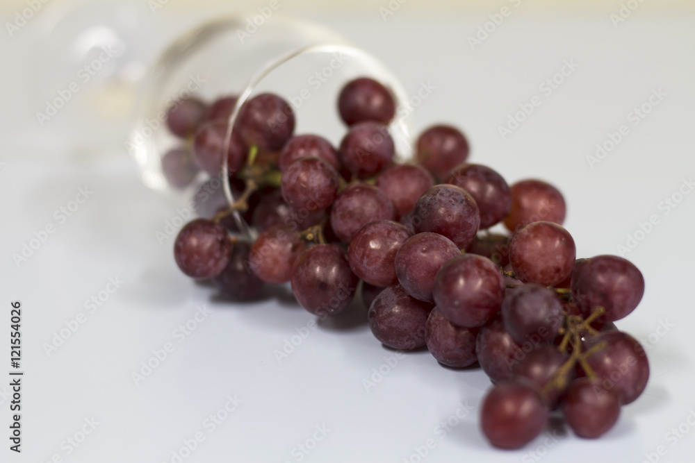 red grape in wine glass , red berry and wine glass on white background