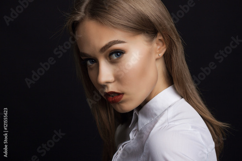 sexy girl in the studio on a black background. He is looking at