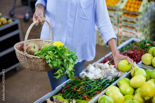 Woman buying sweet lime in organic section