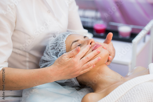 Young woman enjoying facial at spa salon