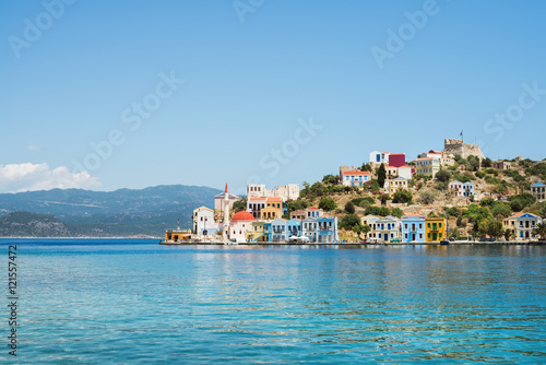View over bay of Kastelorizo on sunny summer day. Island coast with typical colorful Greek houses and clear turquoise sea water. Dodecanese, Greece photo