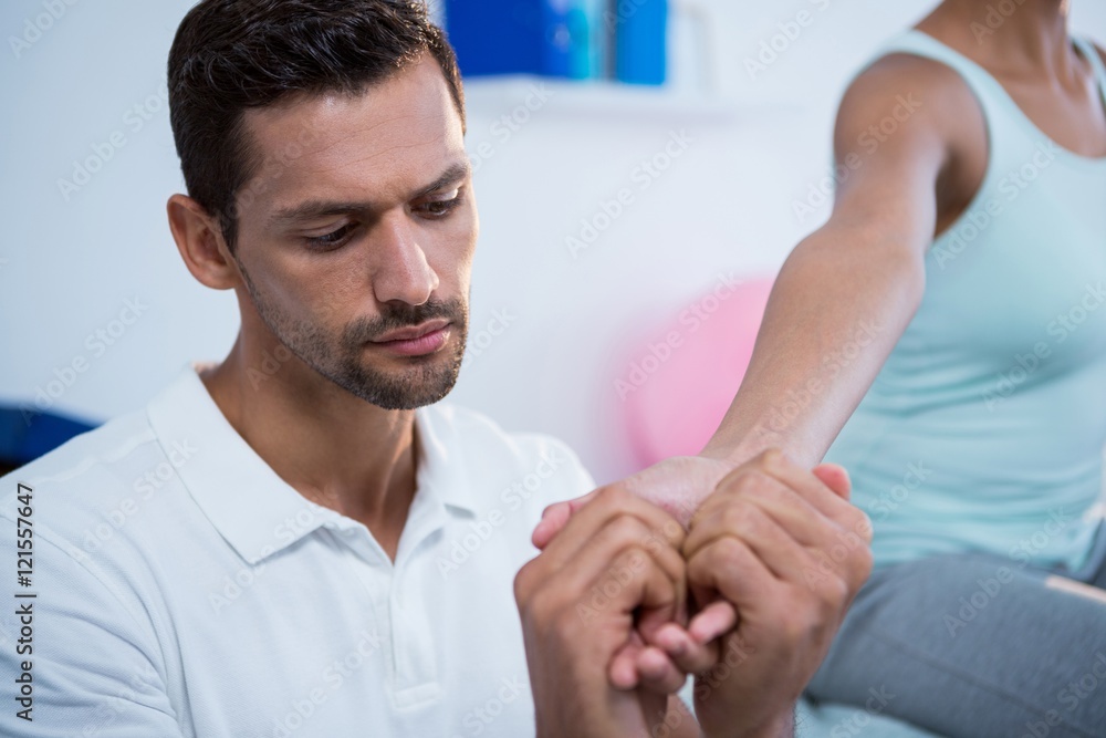 Obraz premium Physiotherapist giving hand massage to a woman