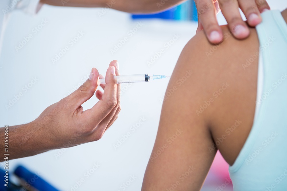 Physiotherapist injecting female patient Physiotherapist injecting female patient