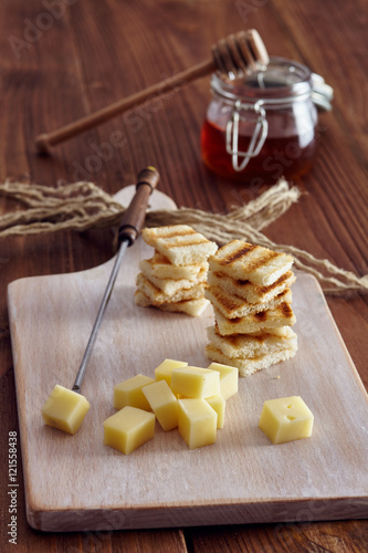 Cheese and honey appetizer, on a chopping board