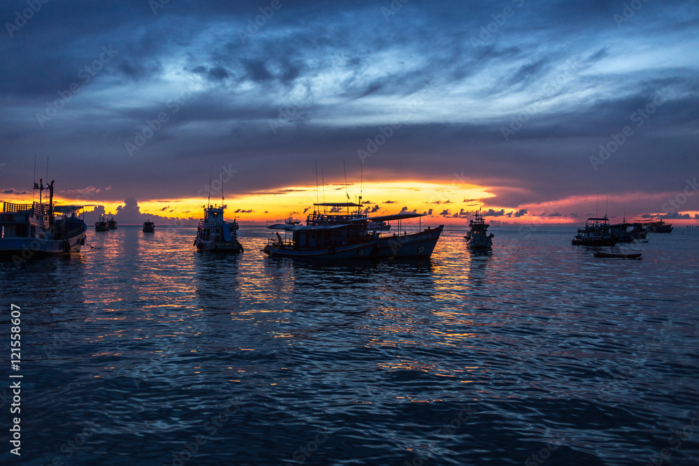 Boats infront of the island while sunset