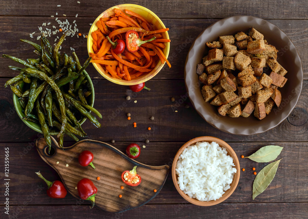 Fototapeta premium Baked vegetables (asparagus beans and carrot), boiled rice and rye croutons. Vegetarian cuisine. The top view
