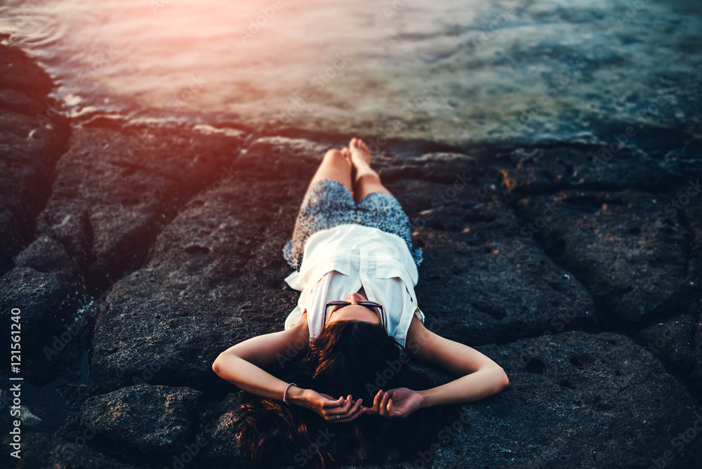 Fototapeta premium Pretty brunette girl relaxing in the stones