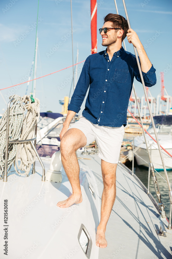 Young stylish sailor man standing on the yacht Young stylish sailor man standing on the yacht