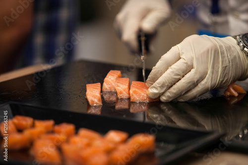 Fotografie Cocinero cortando tacos de salmon
